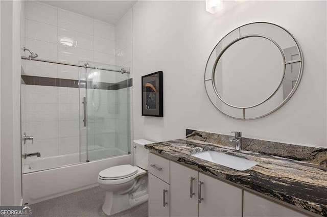 full bathroom featuring combined bath / shower with glass door, vanity, and toilet