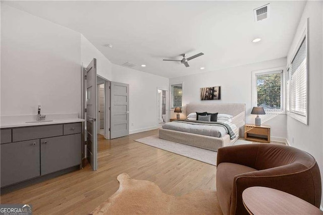 bedroom with sink, light wood-type flooring, and ceiling fan