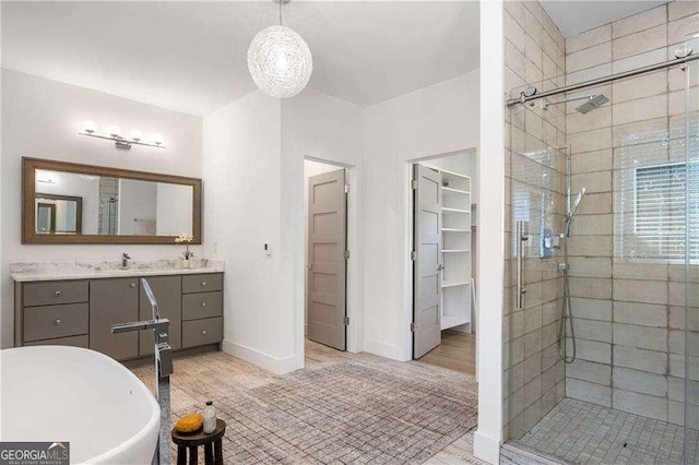 bathroom featuring hardwood / wood-style flooring, vanity, and shower with separate bathtub