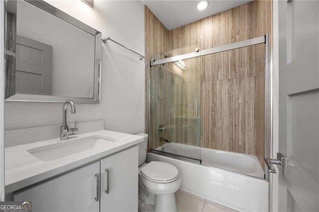 full bathroom with bath / shower combo with glass door, toilet, vanity, and tile patterned flooring