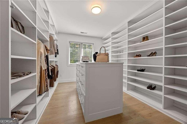 walk in closet with light hardwood / wood-style floors