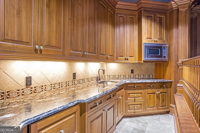 5200 Moore Rd, Suwanee, GA 30024 - kitchen with stainless steel microwave, a sink, decorative backsplash, and brown cabinetry
