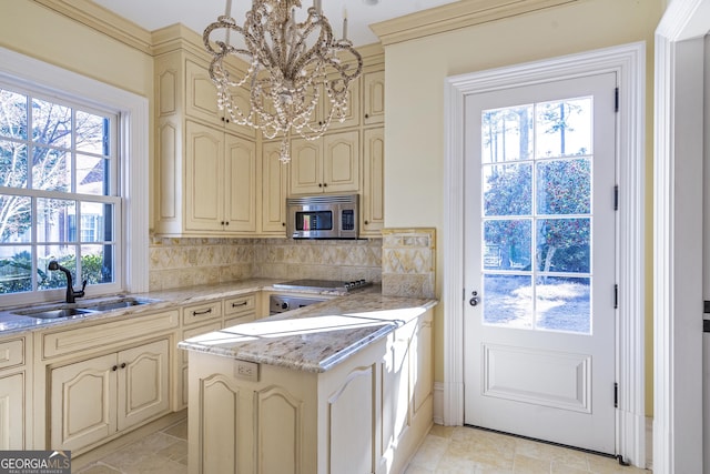 5200 Moore Rd, Suwanee, GA 30024 - kitchen featuring cream cabinets, stainless steel microwave, a sink, a chandelier, and stovetop