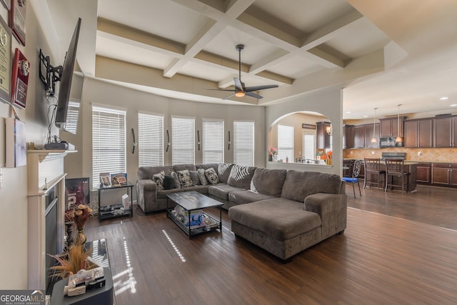 living room featuring coffered ceiling, ceiling fan, beam ceiling, and dark wood-type flooring