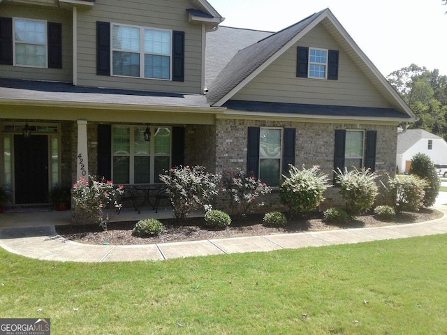 view of front facade featuring a front yard and covered porch