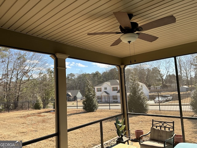 unfurnished sunroom with ceiling fan