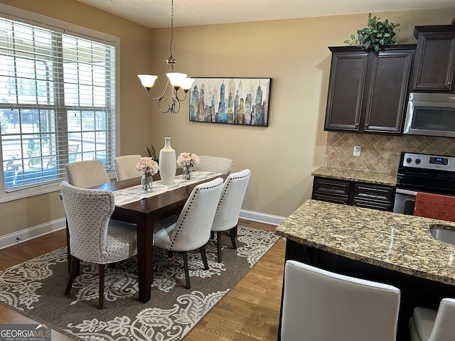 dining area with dark hardwood / wood-style floors and a chandelier