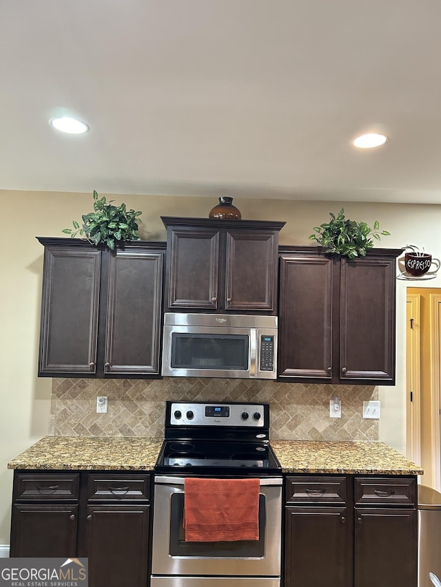 kitchen with stainless steel appliances, light stone countertops, dark brown cabinetry, and decorative backsplash