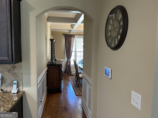 hall with beamed ceiling, crown molding, coffered ceiling, and dark wood-type flooring