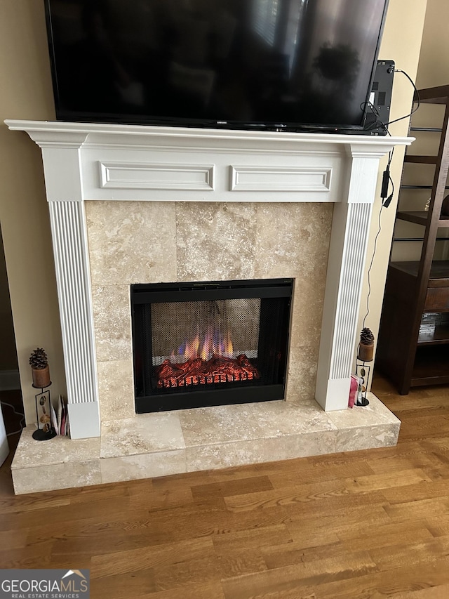 room details with hardwood / wood-style flooring and a tile fireplace