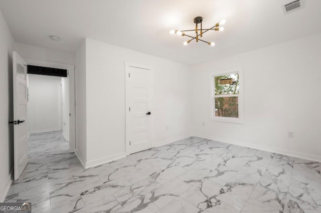 unfurnished room with a notable chandelier