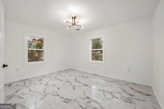 spare room with an inviting chandelier