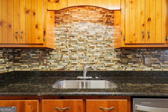 kitchen with decorative backsplash, sink, and dark stone counters