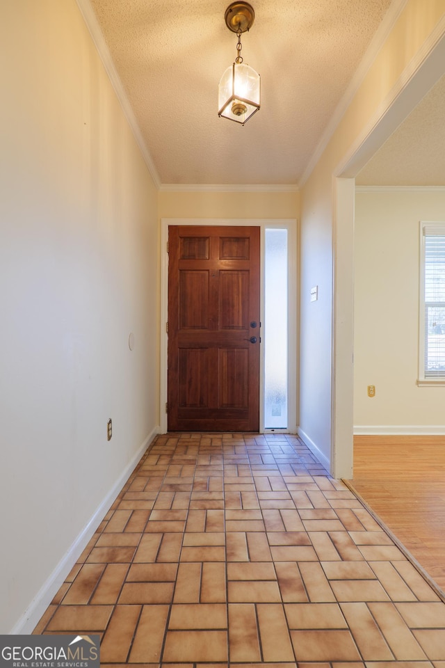 foyer entrance with a textured ceiling and ornamental molding