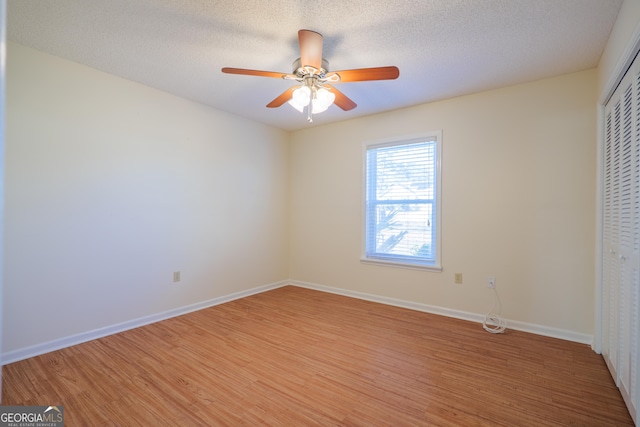 unfurnished bedroom featuring a closet, ceiling fan, a textured ceiling, and wood-type flooring