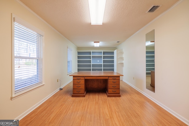 unfurnished office with ornamental molding, light hardwood / wood-style flooring, and a textured ceiling