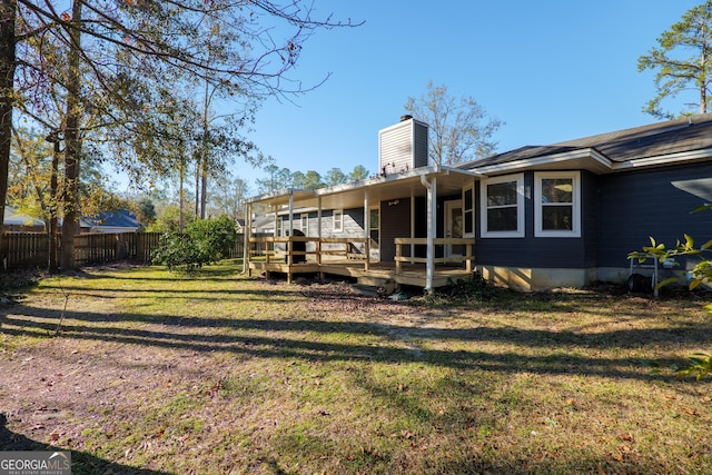 back of house with a wooden deck and a yard