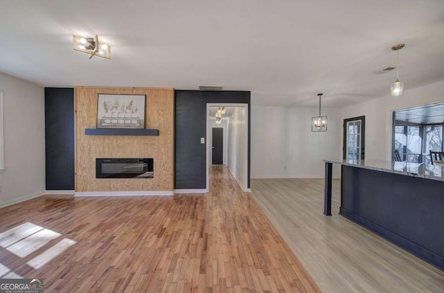 unfurnished living room with light hardwood / wood-style flooring and a large fireplace