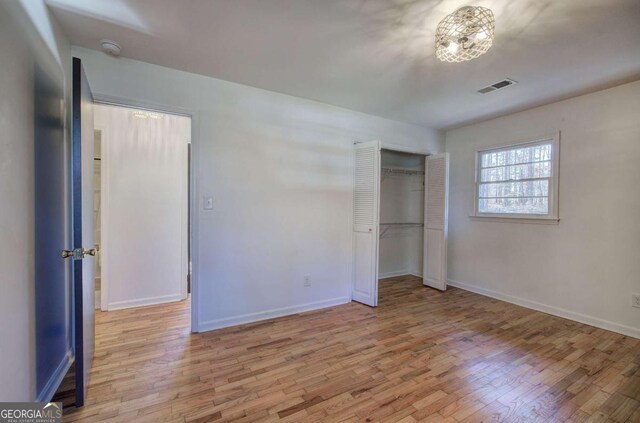 unfurnished bedroom with light hardwood / wood-style floors and a closet