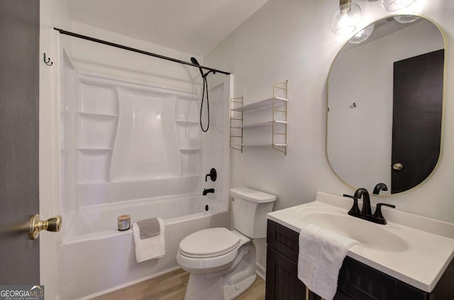 full bathroom featuring washtub / shower combination, wood-type flooring, toilet, and vanity