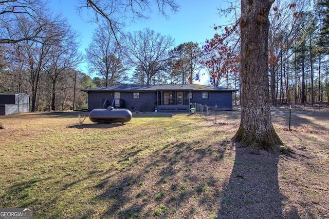 back of property featuring a shed and a lawn