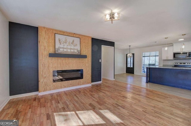 unfurnished living room featuring light hardwood / wood-style flooring and a fireplace