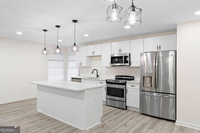 kitchen featuring decorative light fixtures, white cabinetry, a center island, and stainless steel appliances