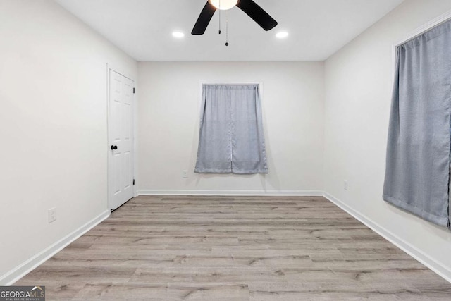 spare room with light wood-type flooring and ceiling fan