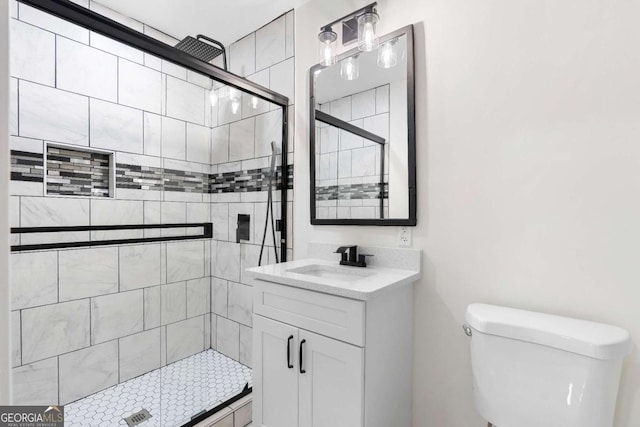 bathroom featuring a shower with door, toilet, and vanity