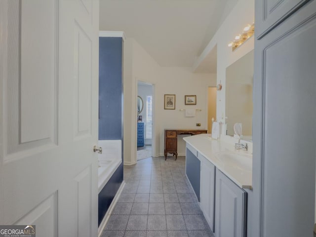 bathroom featuring a washtub, tile patterned floors, and vanity