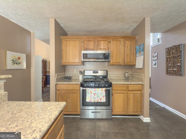 kitchen featuring dark tile patterned floors and stainless steel appliances