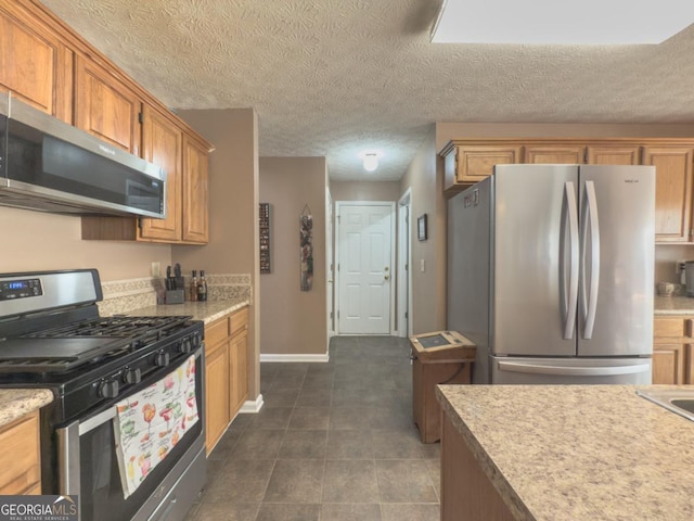 kitchen with a textured ceiling and appliances with stainless steel finishes