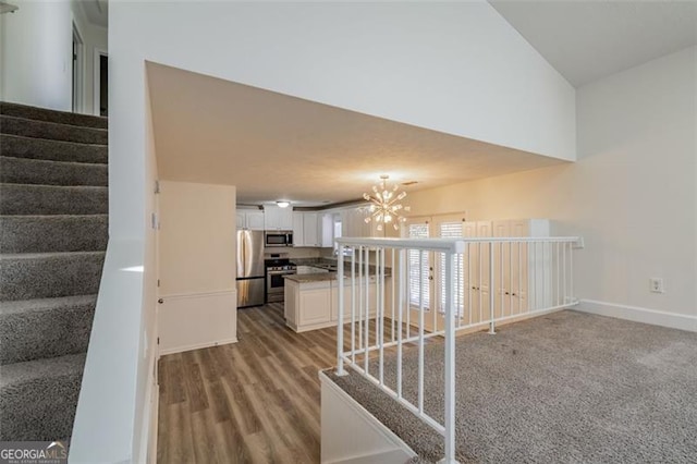 corridor featuring hardwood / wood-style flooring and a chandelier