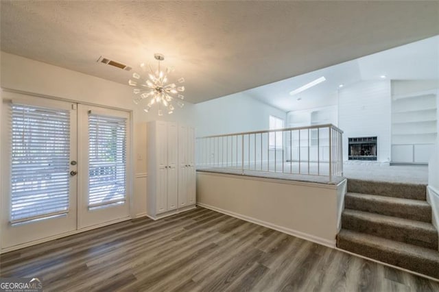 interior space featuring french doors, dark hardwood / wood-style floors, and an inviting chandelier