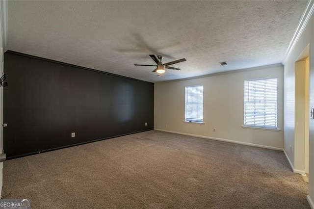 empty room with crown molding, carpet flooring, a textured ceiling, and ceiling fan