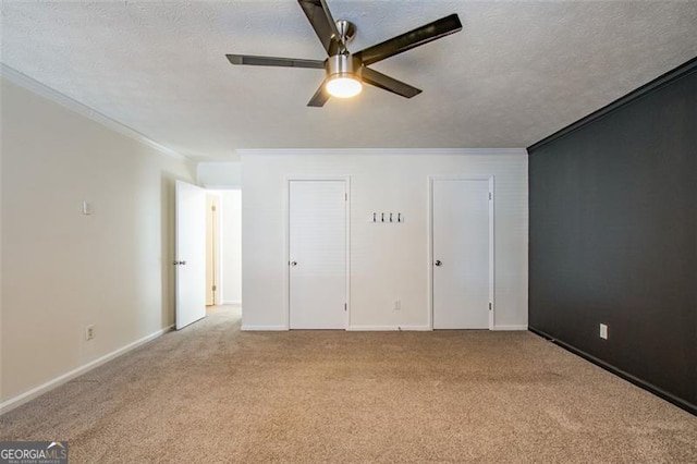 unfurnished bedroom with ornamental molding, light carpet, ceiling fan, and a textured ceiling