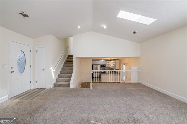 unfurnished living room with carpet flooring and lofted ceiling with skylight