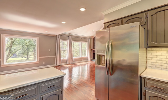 kitchen with crown molding, plenty of natural light, gray cabinets, and stainless steel fridge with ice dispenser