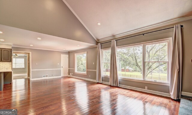 unfurnished living room with crown molding, high vaulted ceiling, and hardwood / wood-style floors