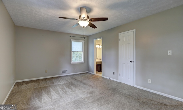 unfurnished bedroom with ensuite bathroom, light carpet, ceiling fan, and a textured ceiling