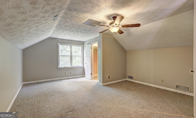 additional living space with lofted ceiling, carpet flooring, a textured ceiling, and ceiling fan