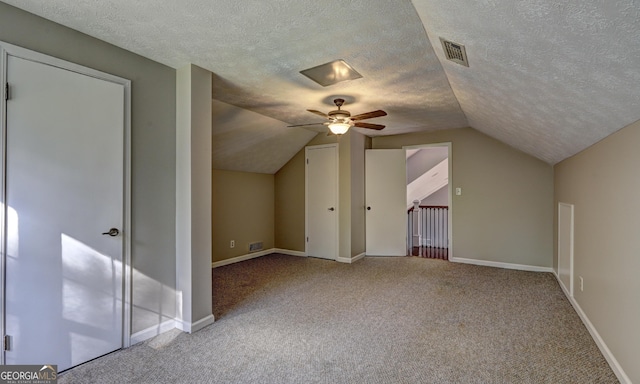 bonus room featuring ceiling fan, carpet floors, vaulted ceiling, and a textured ceiling