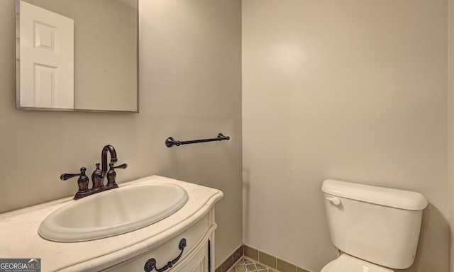 bathroom featuring tile patterned flooring, vanity, and toilet