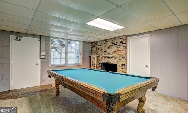 playroom featuring carpet flooring, a brick fireplace, and a drop ceiling