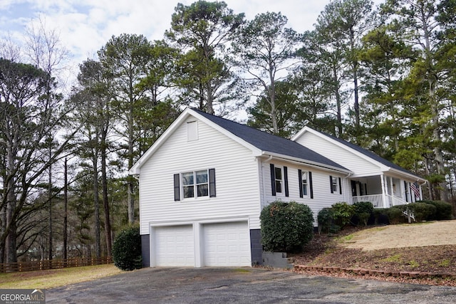 view of side of home with a garage and covered porch