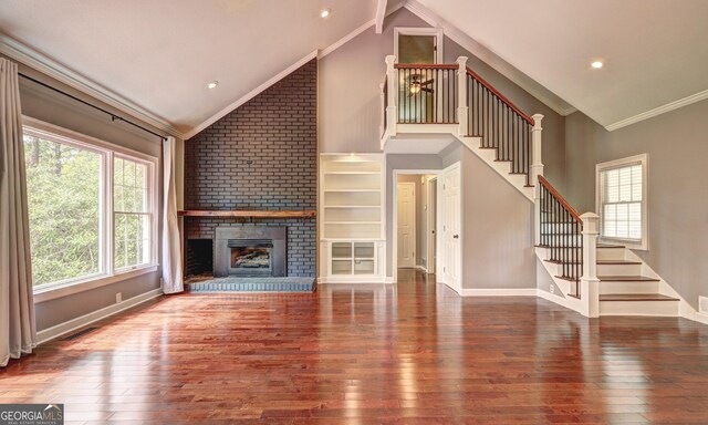 unfurnished living room with dark hardwood / wood-style flooring, crown molding, a fireplace, and high vaulted ceiling