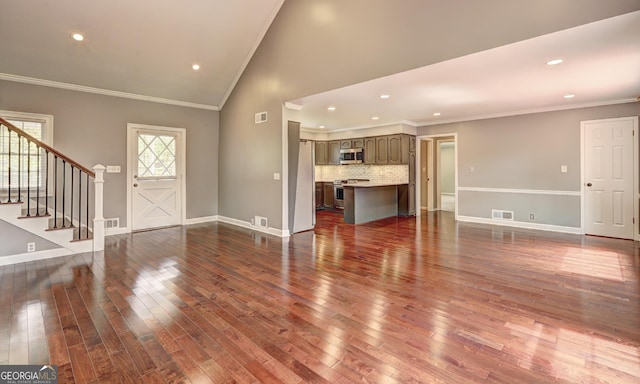 unfurnished living room with high vaulted ceiling, dark wood-type flooring, and ornamental molding