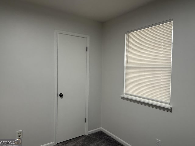 empty room featuring dark colored carpet