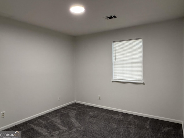 empty room with dark colored carpet