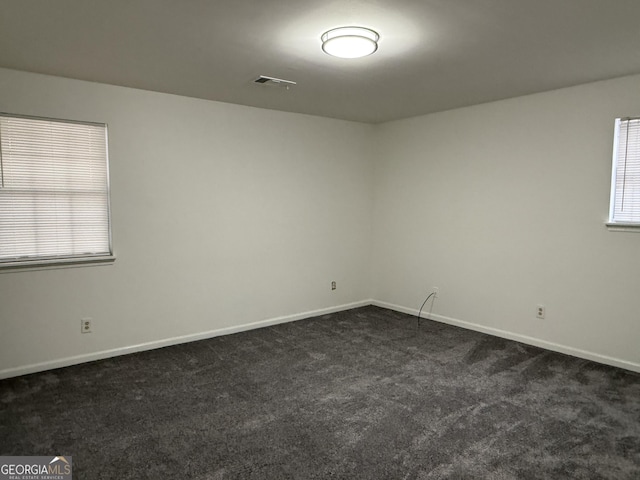 spare room with dark colored carpet